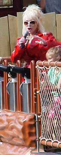 Dolly Parton speaks to the crowd from a Dollywood ride.